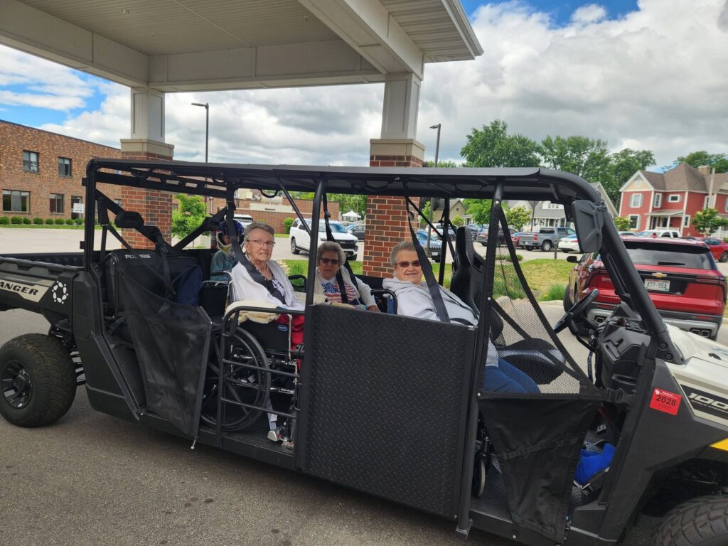 Seniors enjoying a ride in a wheelchair accessible UTV at Morrow Home in Sparta, WI